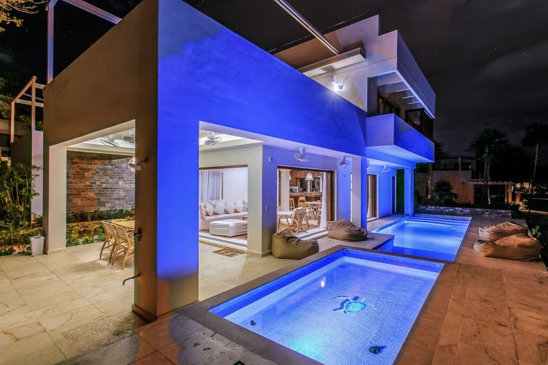 Contemporary Beach Home at Night With Well-Lit Pools