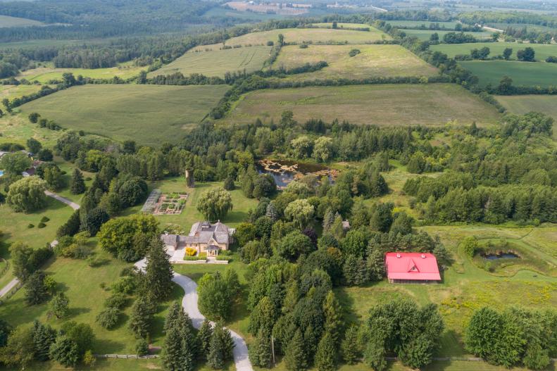 Aerial Shot Of Entire Property Including Home, Driveway, And Gardens