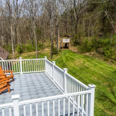 Deck With Adirondack Chairs Looking Over Forested Area