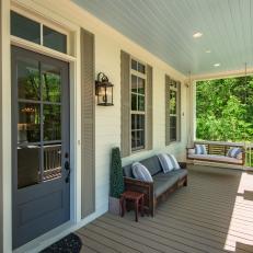 Porch With Gray Front Door Plus Sofa and Porch Swing