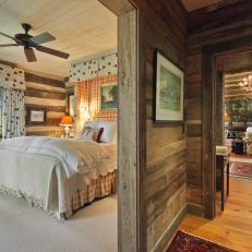Log Cabin Bedroom With Short Hallway and Floral Curtains
