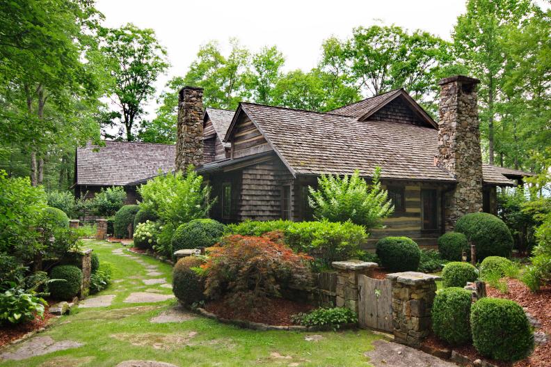 Log Mansion With Stone Chimneys and Garden With Flagstone Pathway