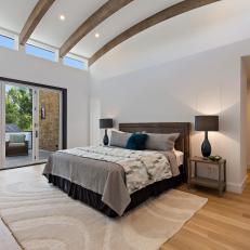 Neutral Contemporary Bedroom With Arched Ceiling Beams