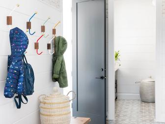 If you're going for minimal, you can still keep your mudroom gleaming. According to Michael Amato, Creative Director of The Urban Electric Co., quality over quantity is key—and it can cost you less. He suggested choosing an open light source in your mud room, like designer Courtney Bishop did here: Bulb options are unlimited and it adds to a mud room's function and style. "As far as the light [in this mud room] goes, our hand turned wooden base has a subtlety in its shape and grain that's highlighted in the setting. It gets a lot of attention but isn’t competing, as it complements the wood bench and wall hooks," Michael e explains. 