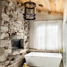 Rustic Bathroom With Soaking Tub And Stone Fireplace