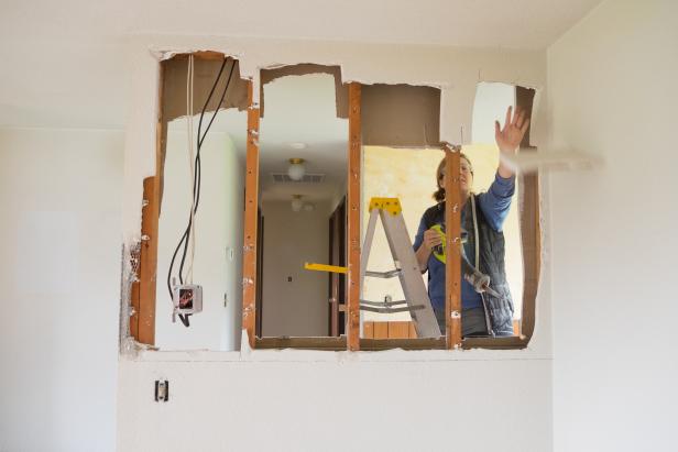 Woman removing a wall during an interior remodel.