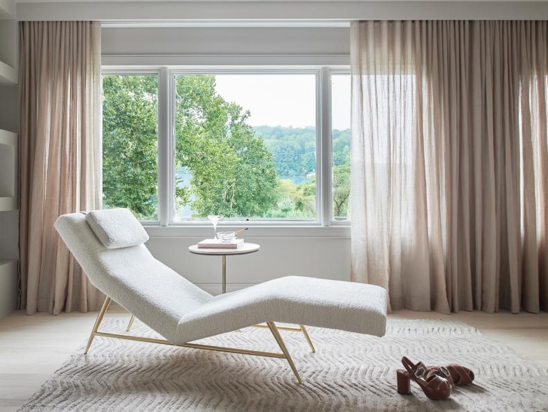 Neutral Toned Floor Rug And Chair Near Large Window With Lake Views