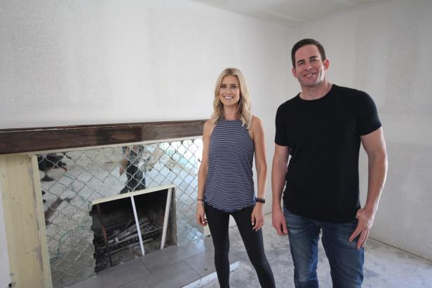 Hosts Christina and Tarek El Moussa stand in front of the finished fireplace of this Fullerton, CA home, as seen on HGTV's Flip or Flop.