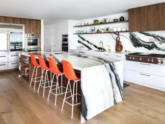 Four High-Back Bar Chairs Line The Oversized Marble Kitchen Island 