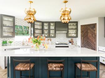 Two Gold-Colored Petal Pendant Lights Hang Above Large Marble Island