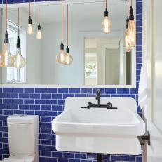 Powder Room With Bold Blue Subway Tiles and Whimsical Light Fixture