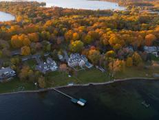 Aerial View of Lakefront Manor Home Nestled Among Autumn Trees