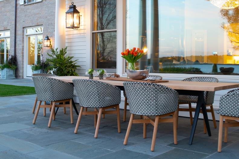 Exterior Dining Area With Wood Table, Patterned Chairs on Stone Floor