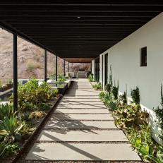 Inviting Covered Walkway Trimmed With Lush Desert Friendly Plants