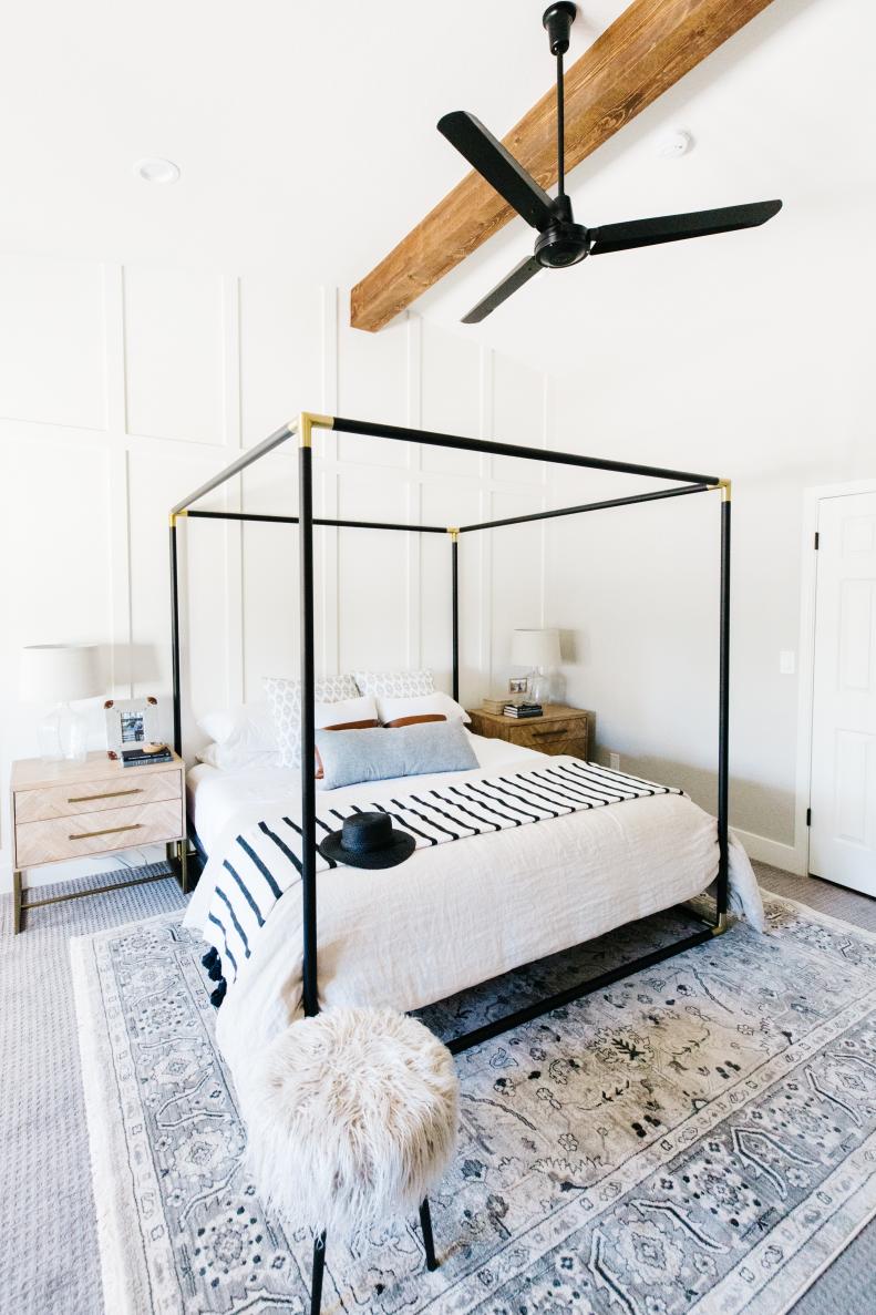 Close Up View Of Black Four Poster Bed With Ceiling Fan Above