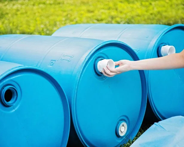 Using plumbing tape first, screw in the threaded pipe to each barrel.