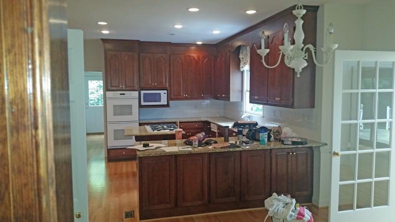 A dated and dark wood cabinetry kitchen. The kitchen's dark cabinetry and awkwardly placed island did not have flow or functionality.
