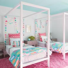 Little Girls Room with Pink Rug and Twin Canopy Beds