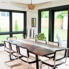 Dining Room Design Blends Heavy, Dark Lines With Curves of Light Fixture