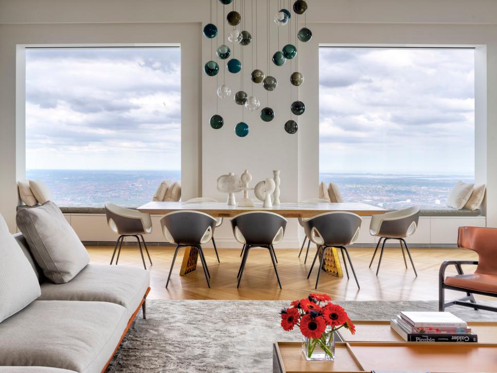 Elegant Dining Table Sits In Front Of Oversized Windows With City View
