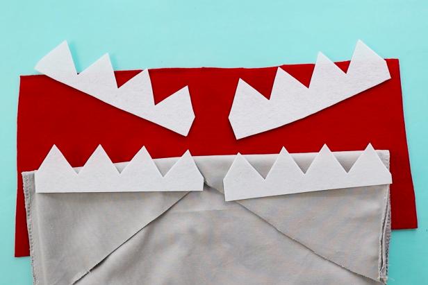 Use stiff white felt to cut four sets of teeth for this shark beach bag. Use red felt to create the inside of the mouth.
