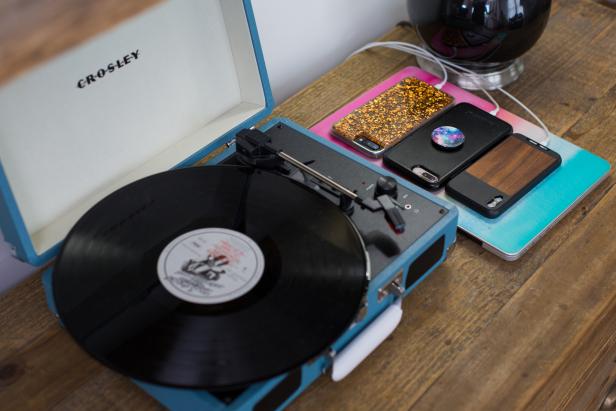 Table With a Record Player and Three Phones Charging