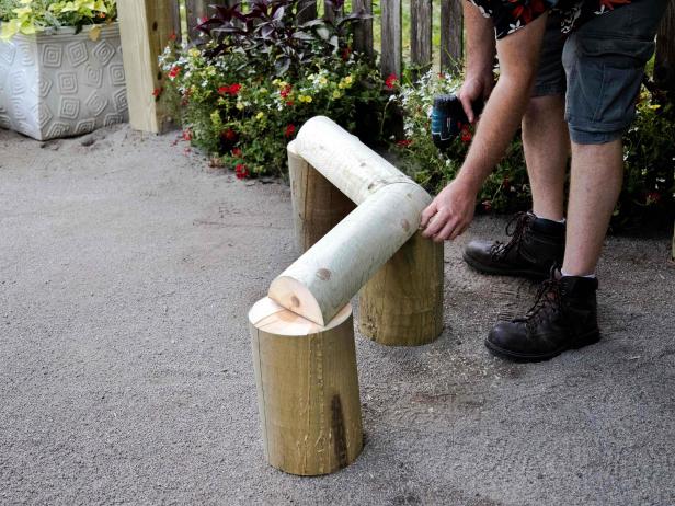 Begin building the structure by attaching two 24” angled half logs onto three different legs.