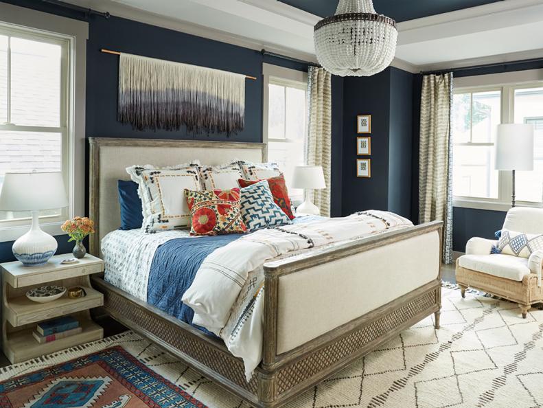 “We filled it with things that made our eyes happy,” says Sonal. That meant navy blue on the walls and the ceiling (Hale Navy by Benjamin Moore) and a glass-bead chandelier from Currey & Company. The various styles of furniture, all neutrals, blend in a cool, relaxed way, including a bed with crisscrossed metal accents and a white upholstered chair (both from RH) plus a whitewashed wood nightstand by Noir. 