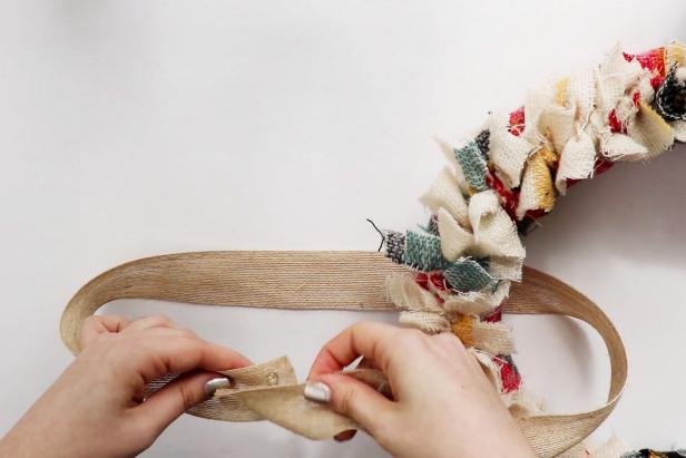 Cut a length of burlap ribbon and thread it through the wreath. Use hot glue to glue it closed. Tie a bow using the ribbon and glue it onto the wreath.
