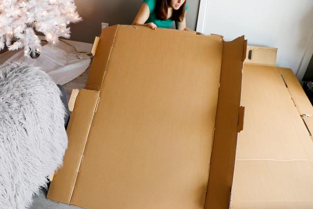 Cut open your cardboard box to get large sheets of cardboard. Tape to the wall and draw your fireplace shape.