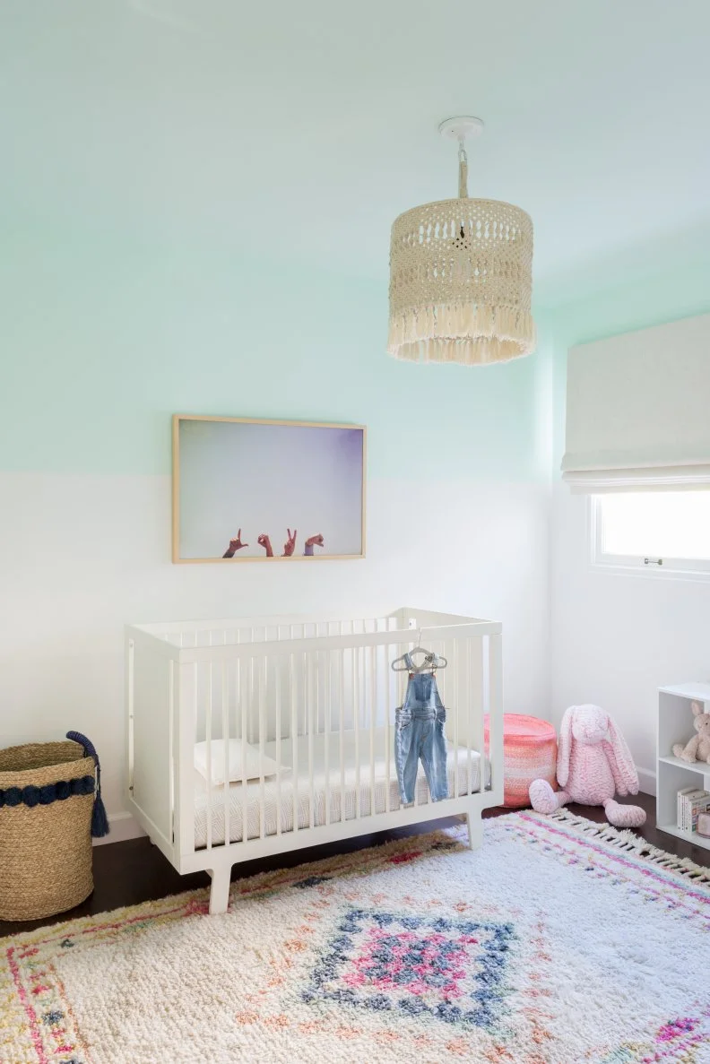 Nursery With Plush Rug And Crib Beneath Woven Tassel Pendant Light