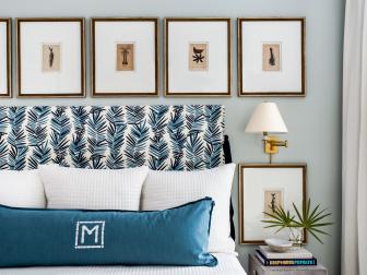 Framed Art Hangs In Straight Line Above Floral Headboard On Bed
