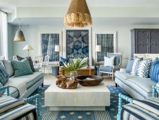Living And Dining Space With Patterned Art, Rug And Pillows On Sofa