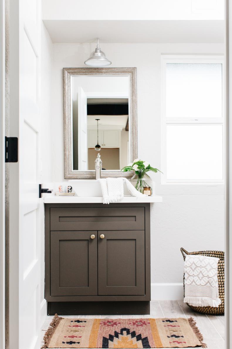 Small Vanity In Powder Room With Rustic Design And Patterned Rug