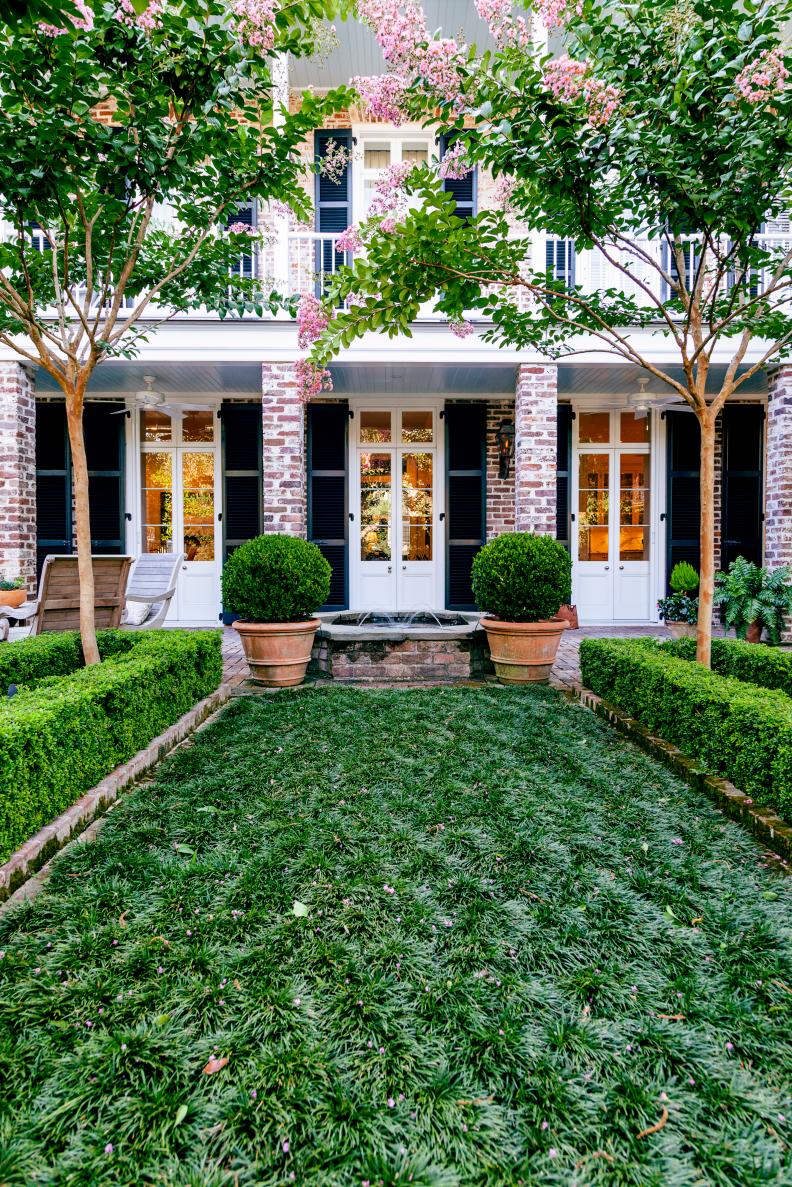 A view of the back of the Rash house shows some of the unique features of the garden including crape myrtles framing the water feature and a "lawn" of mondo grass.