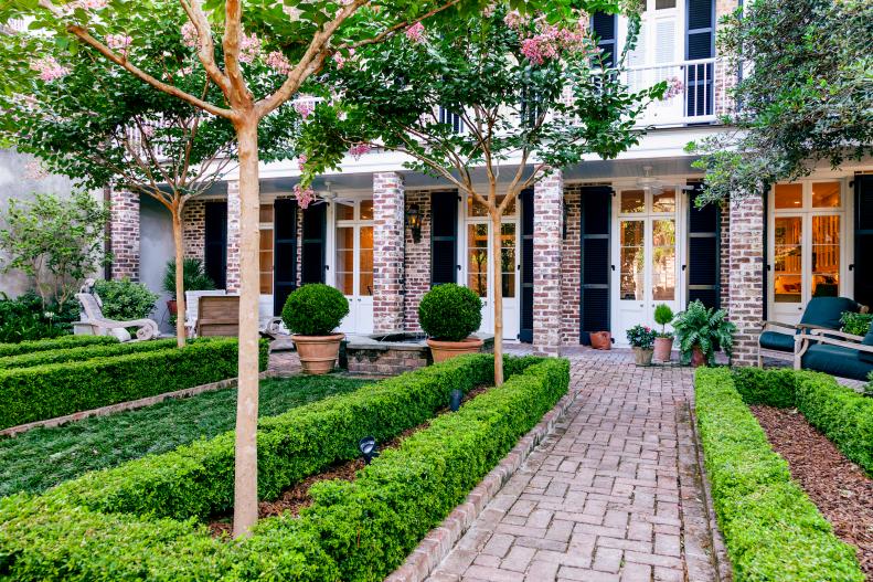 "This is a kind of typical Charleston garden," says Peggy Rash, filled with classic Southern plants like crape myrtle, camellias, sweet bay magnolia, azaleas and tea olive as well as pittosporum, boxwoods and Italian cypress.