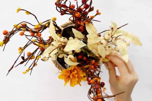 Top off the vase by arranging faux flowers in autumnal hues.