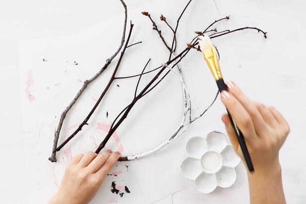 Paint the branches white, allowing some of the bark to show through. You can also lightly sand the branches to give them a weathered look.
