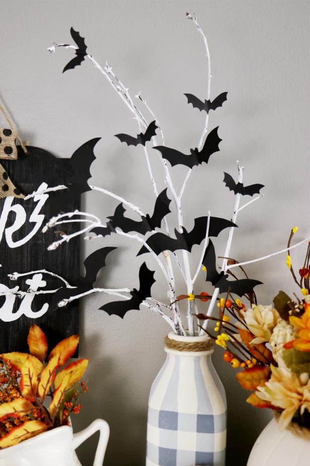 We spray painted a branch from the yard and sanded it to give it a weather look before attaching paper bats for a simple, chic Halloween decoration.