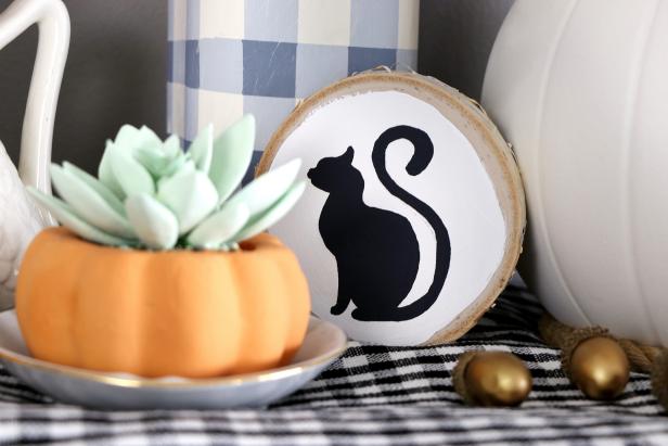 We painted a silhouette of a cat onto a wood round to complement a farmhouse-inspired Halloween display.