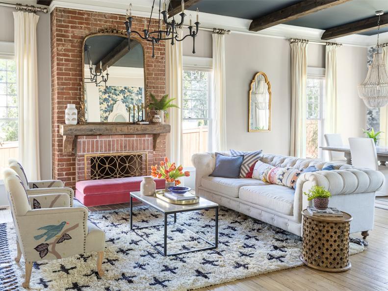 The heart of this space: the swoon-worthy brick fireplace. “I treasured the few things that were still there after the gut job,” Brittany says. She put in rustic beams stained dark walnut and a roll arm sofa from RH to play up the vintage look. But it wouldn’t be a room in her house if it weren’t a little playful; enter a bubble gum pink velvet ottoman and a pair of bird-adorned upholstered armchairs, all from Anthropologie. 