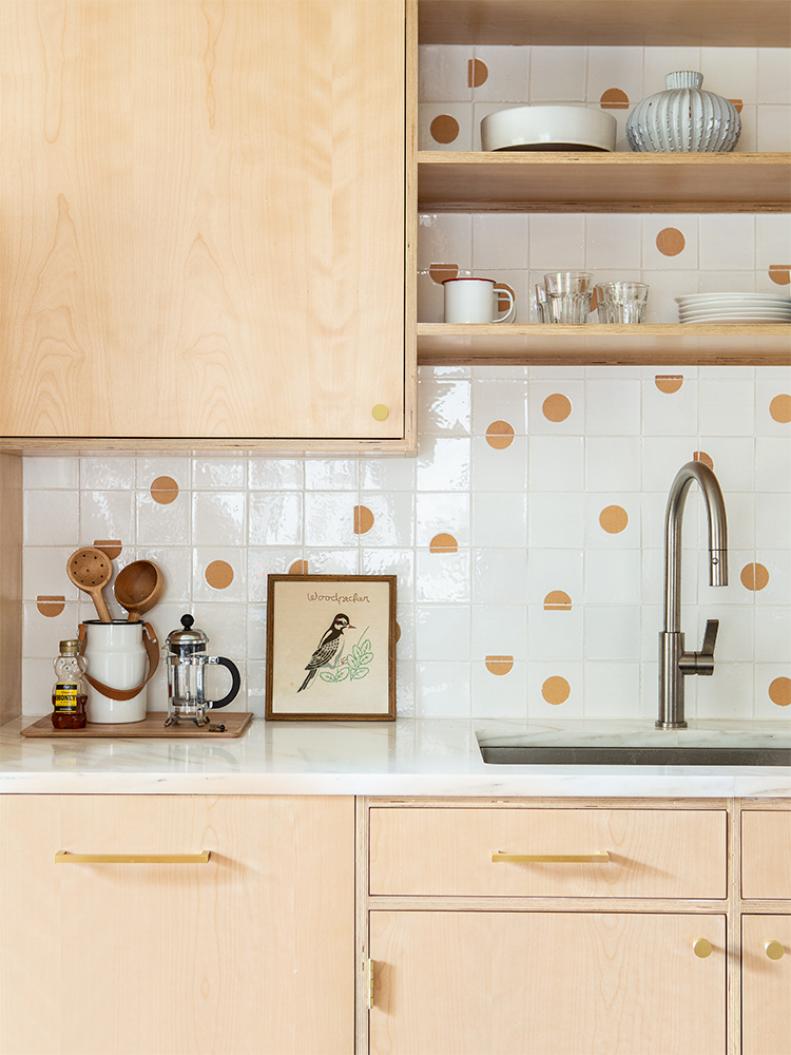 A mix of terra-cotta tiles (by Tempest Tileworks), some all glazed white and some with a dot or a partial dot, is totally awesome. Although their placement may seem random, designer Max Humphrey planned it all out for his Portland, OR, kitchen. “I arranged the tiles on my floor in sections before the install,” he says. “I like the playful design—a backsplash can have a sense of humor!” 