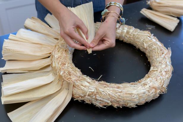 Begin by folding the end of one corn husk together.