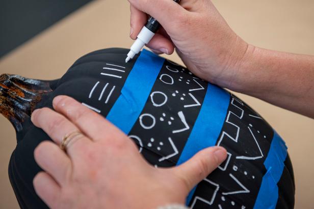 Use a paint marker to draw on mud cloth patterns — which are traditional African symbols — for a trendy design.