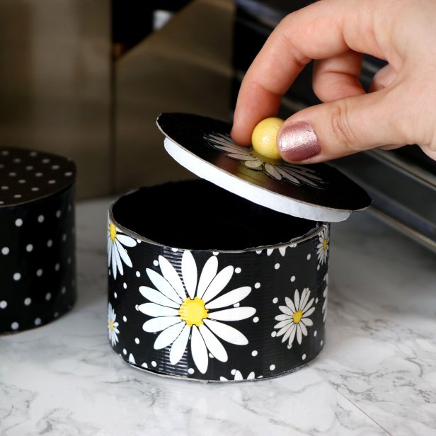 Use your DIY skills to craft a handy storage box out of an empty duct tape roll and decorative tape.