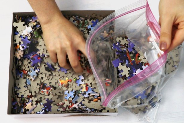 Start by transferring all of the jigsaw puzzle pieces into a large resealable bag