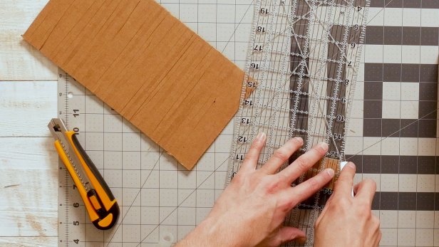 Next, cut a piece of cardboard to size and score horizontally to create flexibility to wrap along the curved backside.