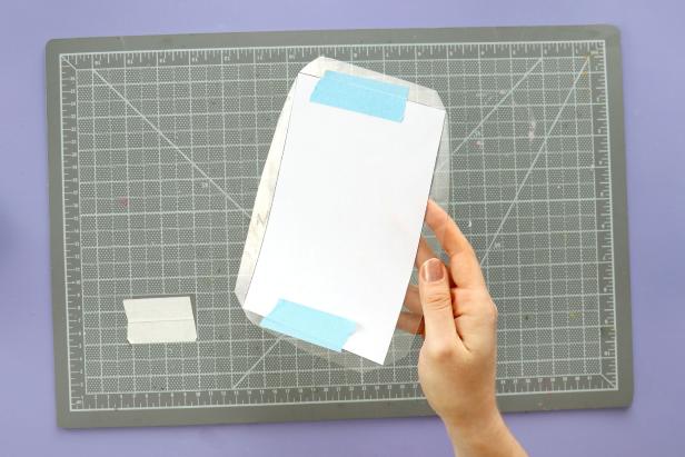 Next, cut the rectangle shape from a clear plastic container such as a salad container. Cut right up to the corners of the pattern but leave a little extra plastic on each side.