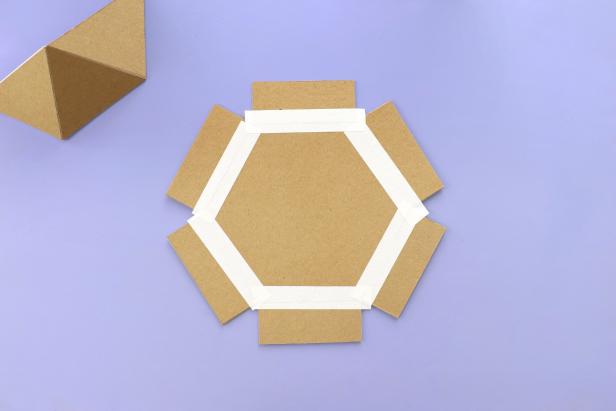 Using masking tape, attach the six rectangles around the hexagon.