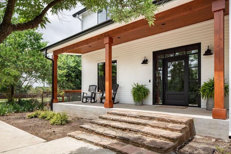Modern Farmhouse Front Entrance With Metal Front Door And Wood Columns